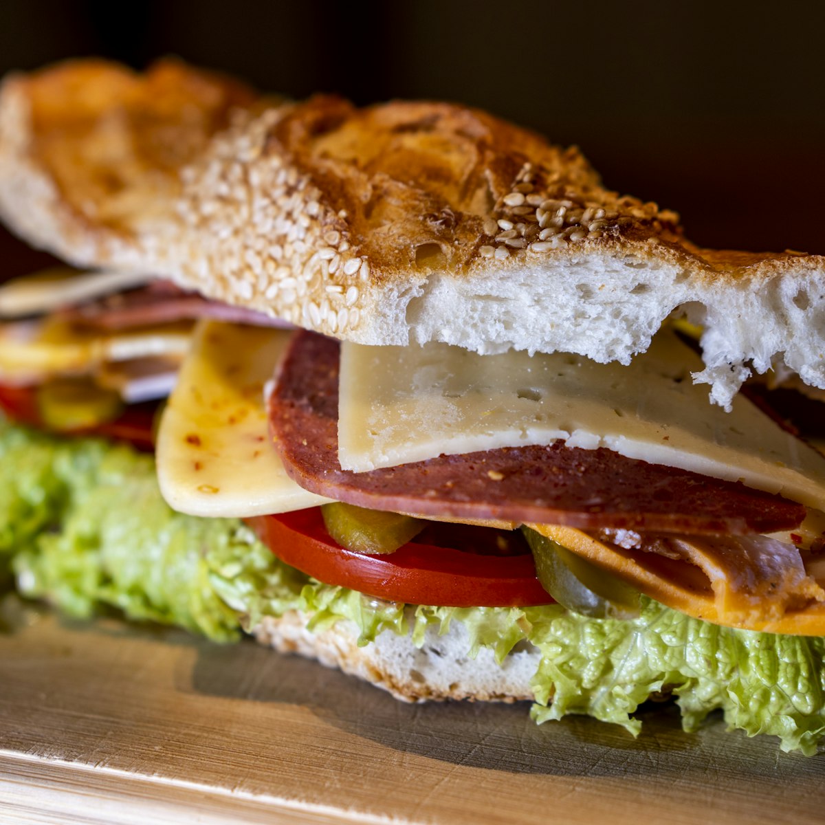 Pressed sesame panini layered with cheese, tomato and greens